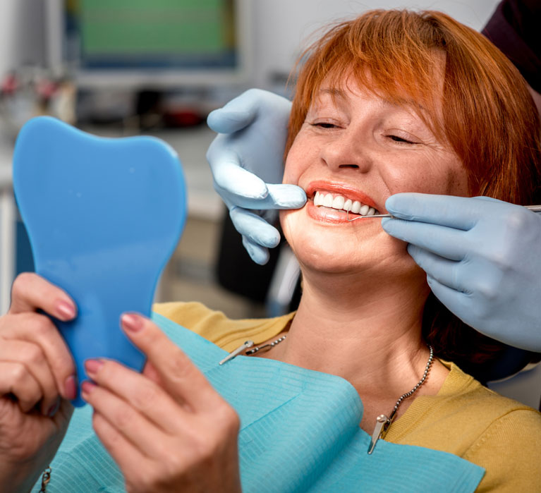 Emergency Dental of America | Image of smiling woman in a dental chair